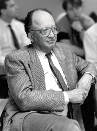 Black and white photo of Dr. Shelton  in a tweed suit and tie with glasses
